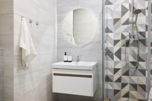 a modern bathroom with stylish geometric tile and a small vanity