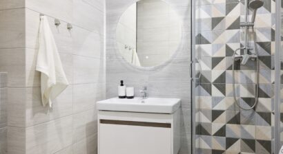 a modern bathroom with stylish geometric tile and a small vanity