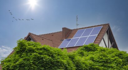 solar panels on roof of house with sun shining and blue sky
