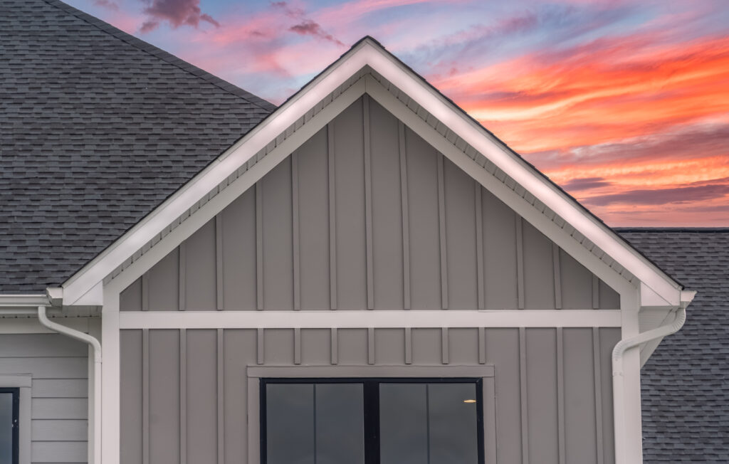 white frame with gray house siding and sunset in background