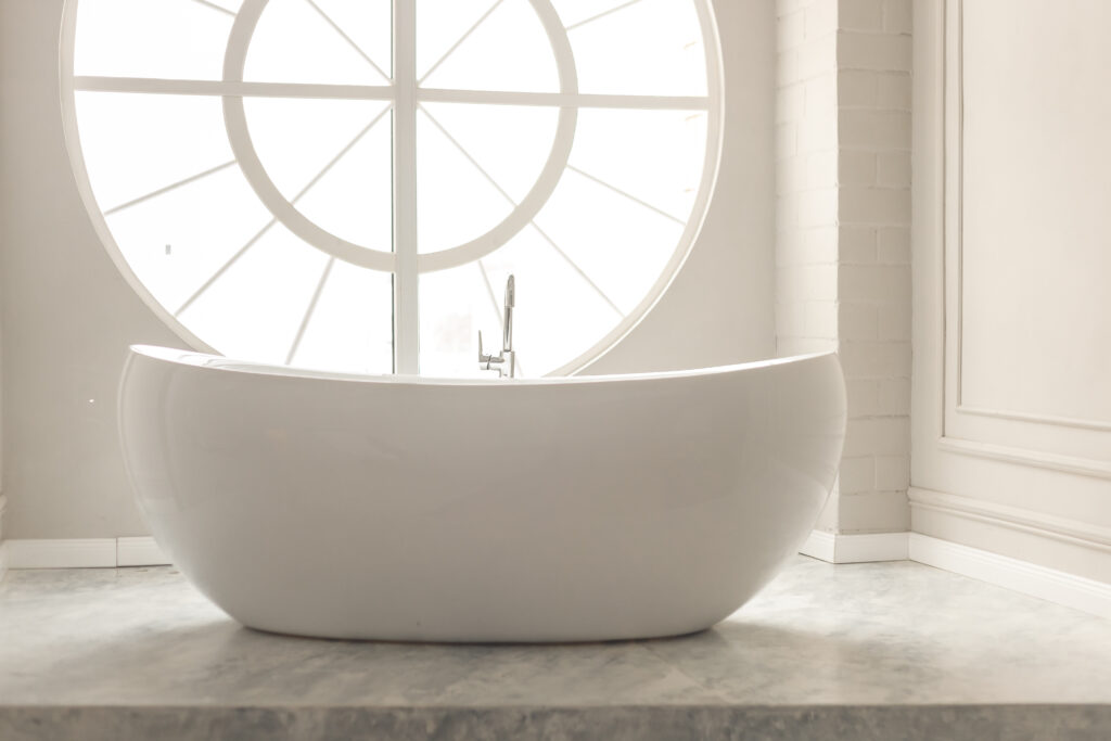 white modern bathroom with white bathtub and round window