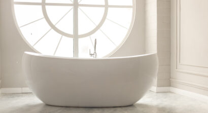 white modern bathroom with white bathtub and round window