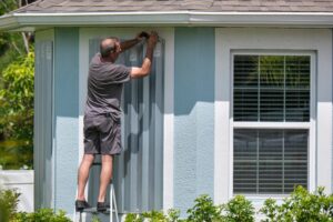 homeowner installing hurricane shutters