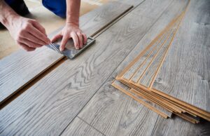 close up of male worker using ruler for flooring installation