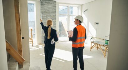 woman and contractor standing in room that is being remodeled