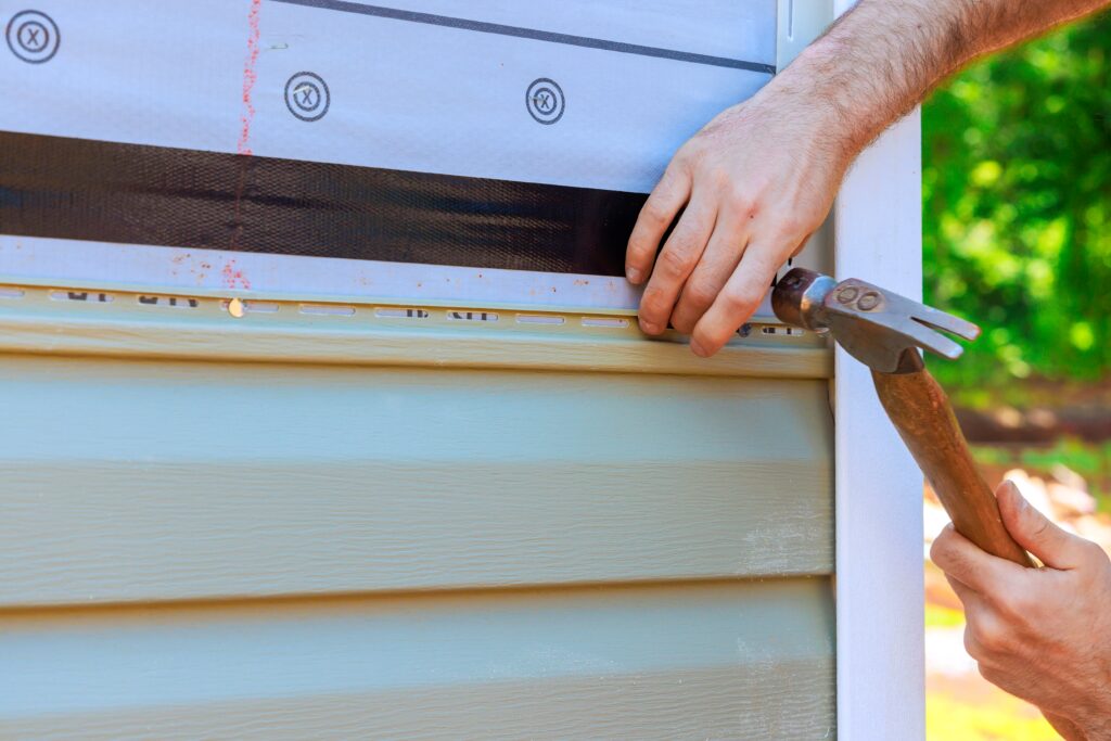 contractor skillfully applying siding to a house