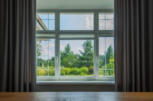 an outdoor view from a window with curtains