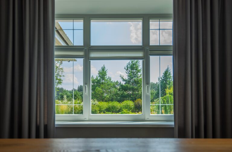 an outdoor view from a window with curtains