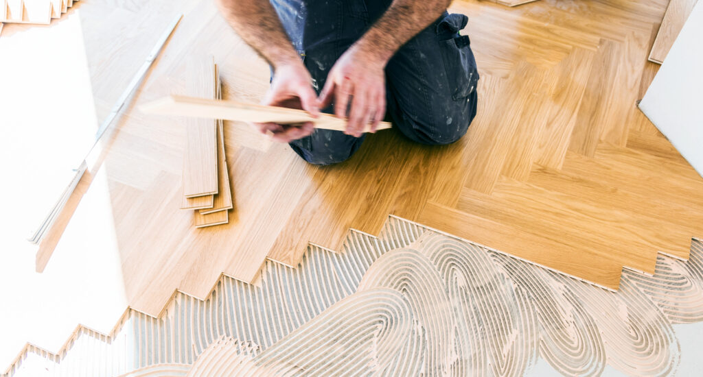 worker installing oat floor during home improvement