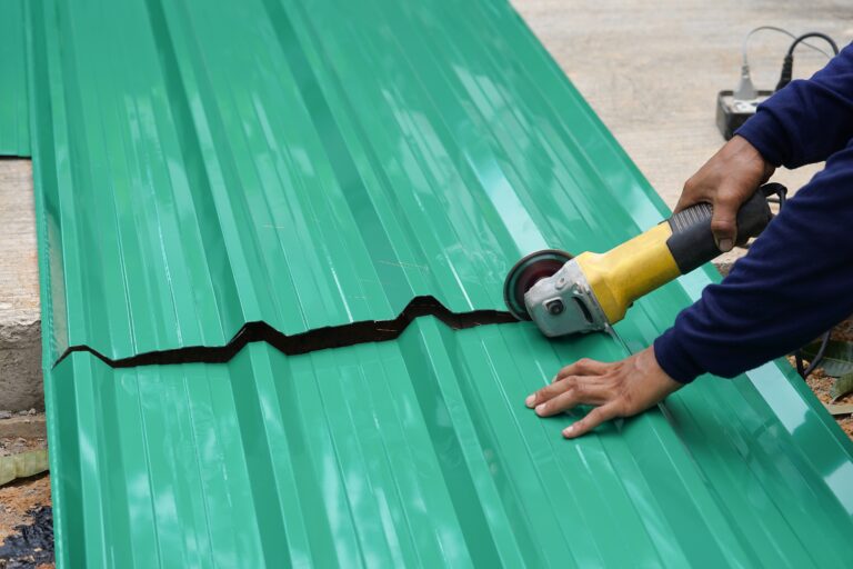 hands cutting a metal roof with tool