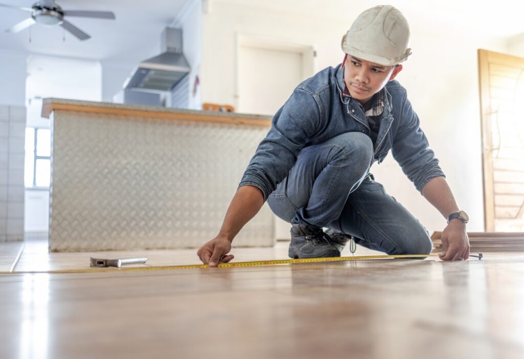 male carpenter measuring floor