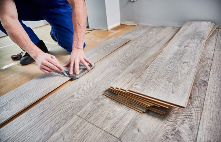 man preparing laminate flooring for install
