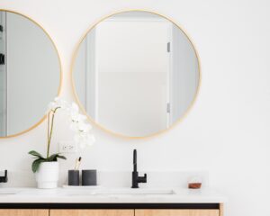 bathroom vanity with mirrors hanging side by side above