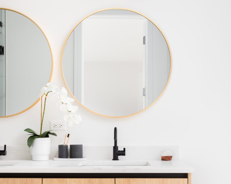 bathroom vanity with mirrors hanging side by side above