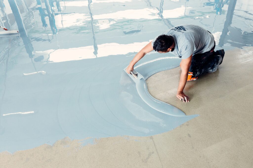 construction worker on the ground with epoxy flooring